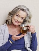 Ältere Frau mit einem Glas Tee