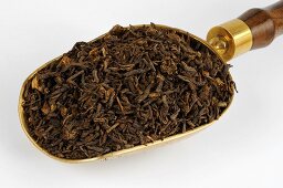 Dried aster root in a scoop