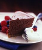 A piece of chocolate cake with whipped cream and berries