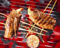 Beef and prawn skewers on a barbecue