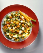 A plate of buttered vegetables with gherkins