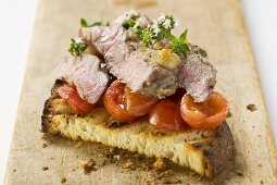 Beef steak with cherry tomatoes on toasted bread