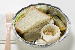Tuna sandwich with coleslaw and gherkin in lunch box