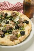 Pizza with tuna, chard and olives, glass of cola