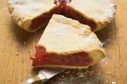 Cherry pie, a slice cut, with slice on knife