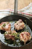 Goat's cheese wrapped in bacon in frying pan