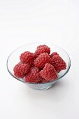 Several raspberries in glass bowl