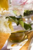 Honey in glass bowl behind piece of croissant