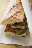 Baguette with grilled vegetables on paper