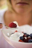 woman eating berry muesli with yoghurt