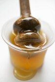 Honey in small bowl with honey dipper