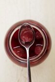 Cherry compote in jar and on spoon