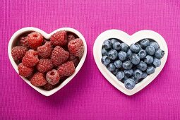 Raspberries and blueberries in heart-shaped dishes