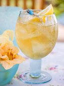 Fruity pineapple drink with ice cubes and lemon