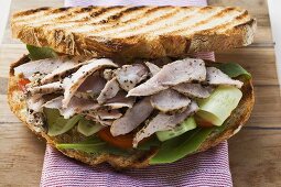 Toasted bread topped with pork and salad