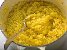 Saffron risotto in pan with spoon