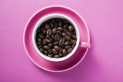 Coffee beans in pink coffee cup