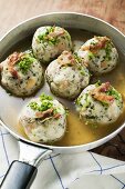 Clear broth with bacon dumplings in frying pan