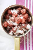 Sugared raspberries in a pan (overhead view)