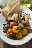 Grilled aubergines with cherry tomatoes, capers, flatbread