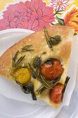 A slice of pizza with cherry tomatoes, capers and rosemary