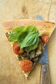 Slice of pizza with tomatoes, aubergines and basil