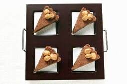 Vier Stücke Schokoladentorte mit Mandeln auf Tablett