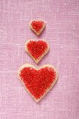 Three heart-shaped biscuits with red sugar