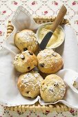 Gezuckerte Rosinenbrötchen und Schälchen Butter im Brotkorb