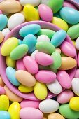 Sugared almonds, in and around pink bowl