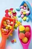 Verschiedene bunte Bonbons auf Plastikschaufeln