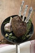 Rack of venison with garlic and rosemary in frying pan