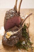 Rack of venison, partly carved, with garlic and rosemary