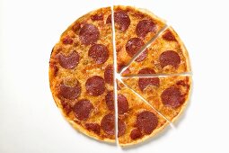 Pepperoni pizza, one half cut into slices