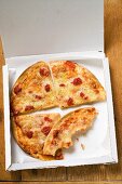 Pizza Margherita in Stücken im Pizzakarton