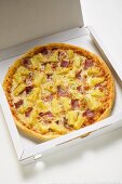 Pizza Hawaii mit Schinken und Ananas im Pizzakarton