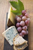 Pieces of Appenzeller and blue cheese, red grapes, bread