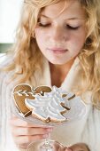 Blond girl holding glass bowl of assorted gingerbread biscuits