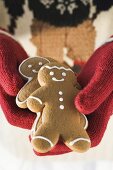 Hands in woollen gloves holding gingerbread men