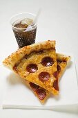 Slices of American-style pepperoni pizza with cola