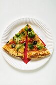 Two slices of American-style vegetable pizza on paper plate