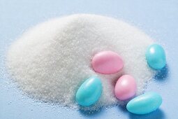 Coloured sugared almonds with a heap of sugar