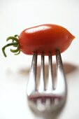 Plum tomato, speared on a fork
