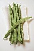 Green beans on linen cloth (overhead view)