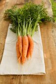 Fresh carrots with tops on linen cloth
