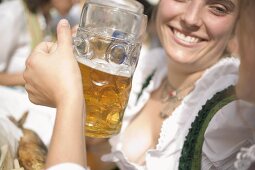 Women clinking two litres of beer together (Oktoberfest, Munich)