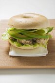 Bagel filled with avocado, tuna salad and capers