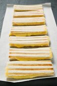 Several toasted cheese sandwiches in a row on paper
