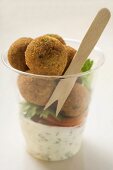Falafel (chick-pea balls) with yoghurt sauce in beaker