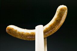 Holzzange hält Bratwurst